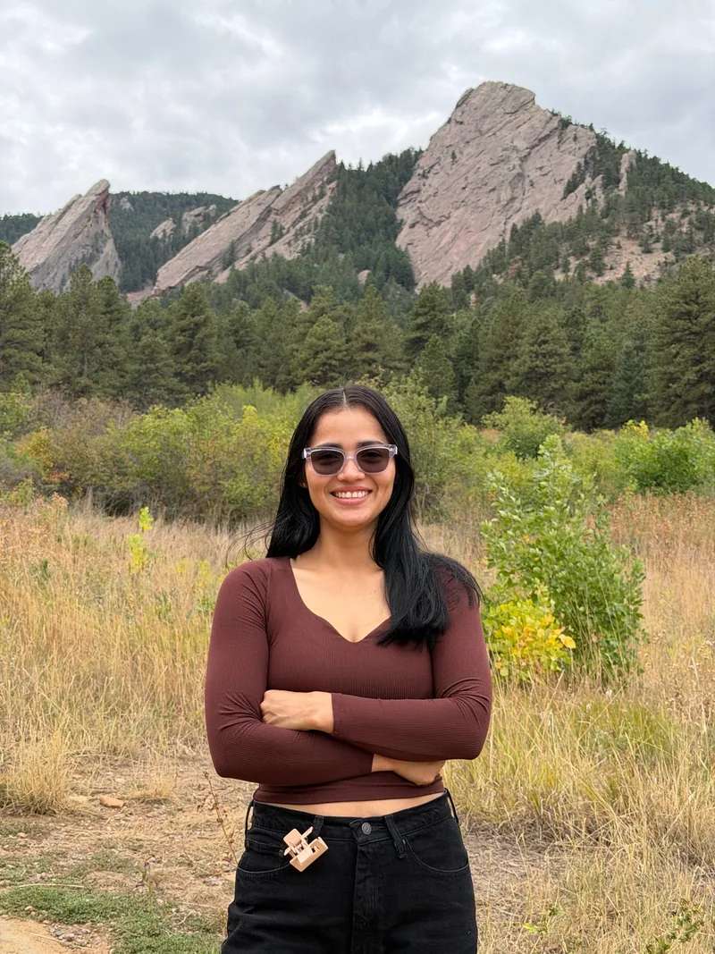 Kattia, owner of Clean by Kattia, smiling in front of Colorado’s Flatirons